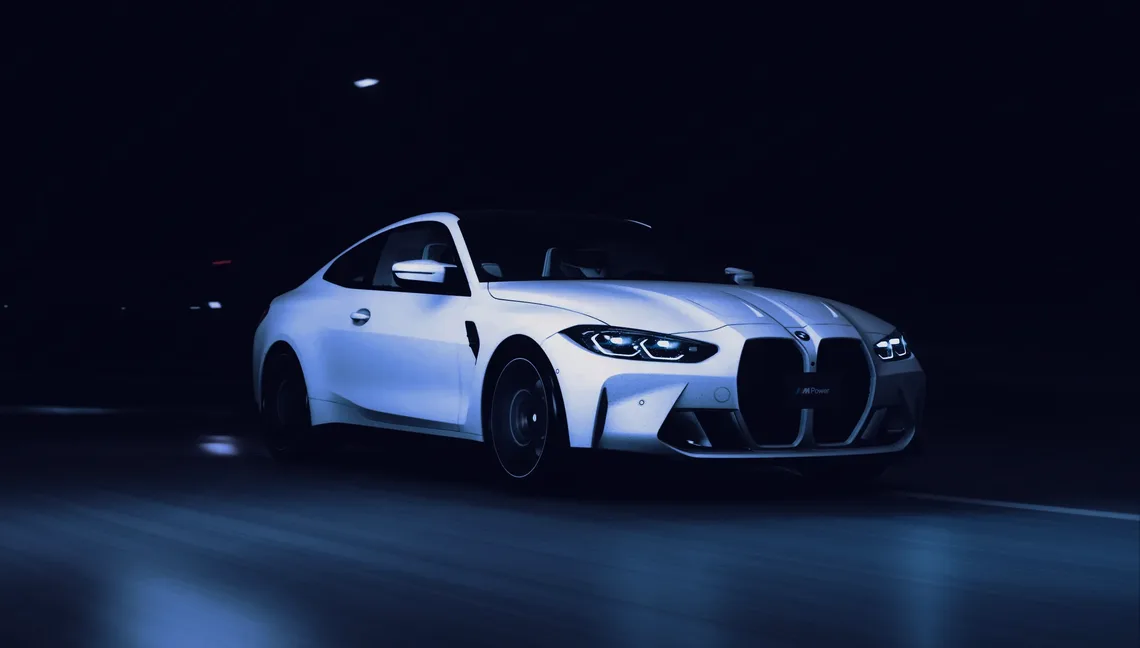 Coupé sportiva grigia davanti a un garage di sera